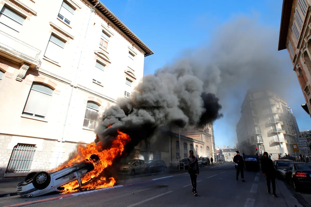 Um carro em chamas durante os confrontos dos estudantes franceses com a polícia em Marselha, França