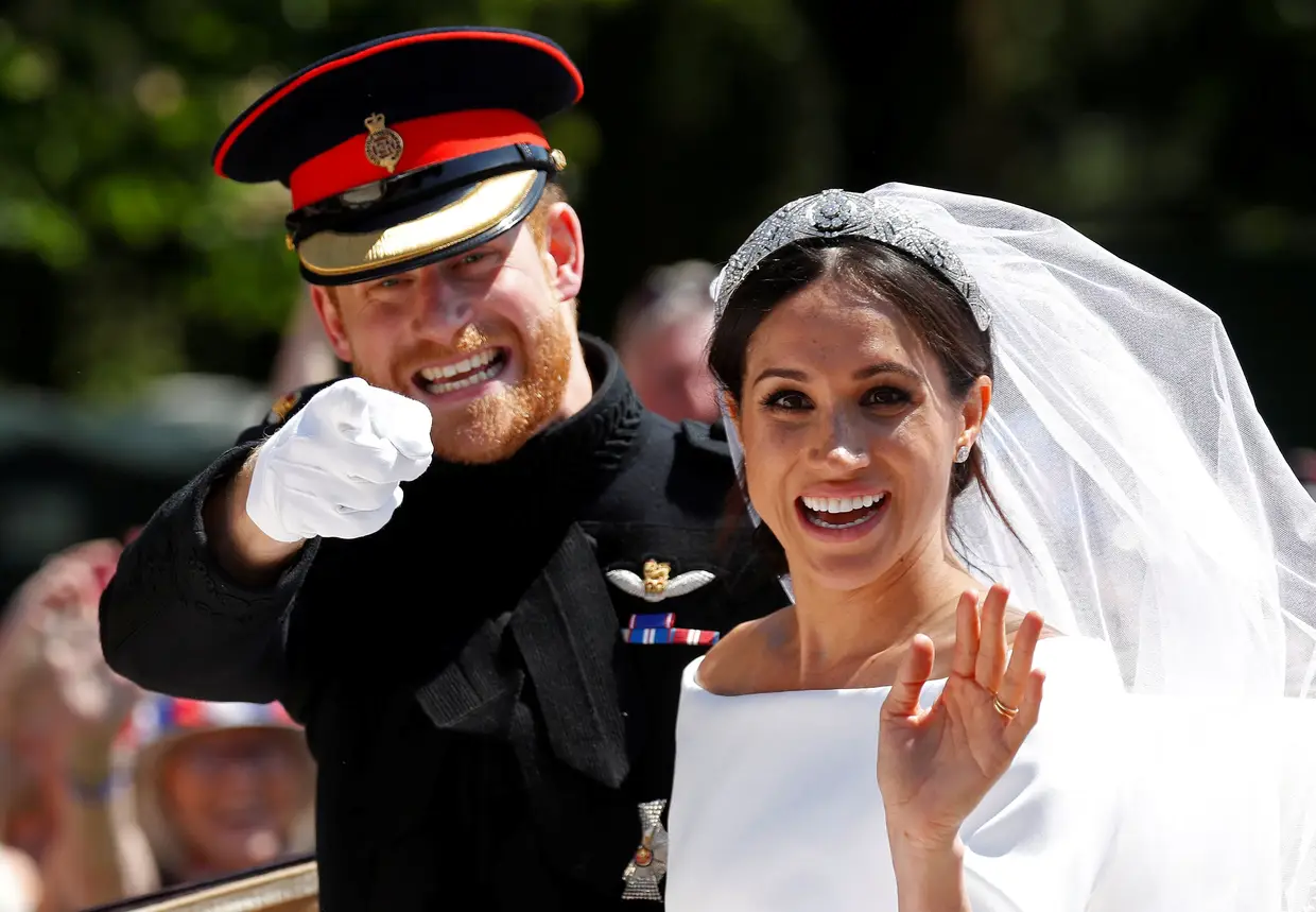 O príncipe Harry e Meghan acenam aos populares depois do casamento na Capela de São Jorge, no Castelo de Windsor.
