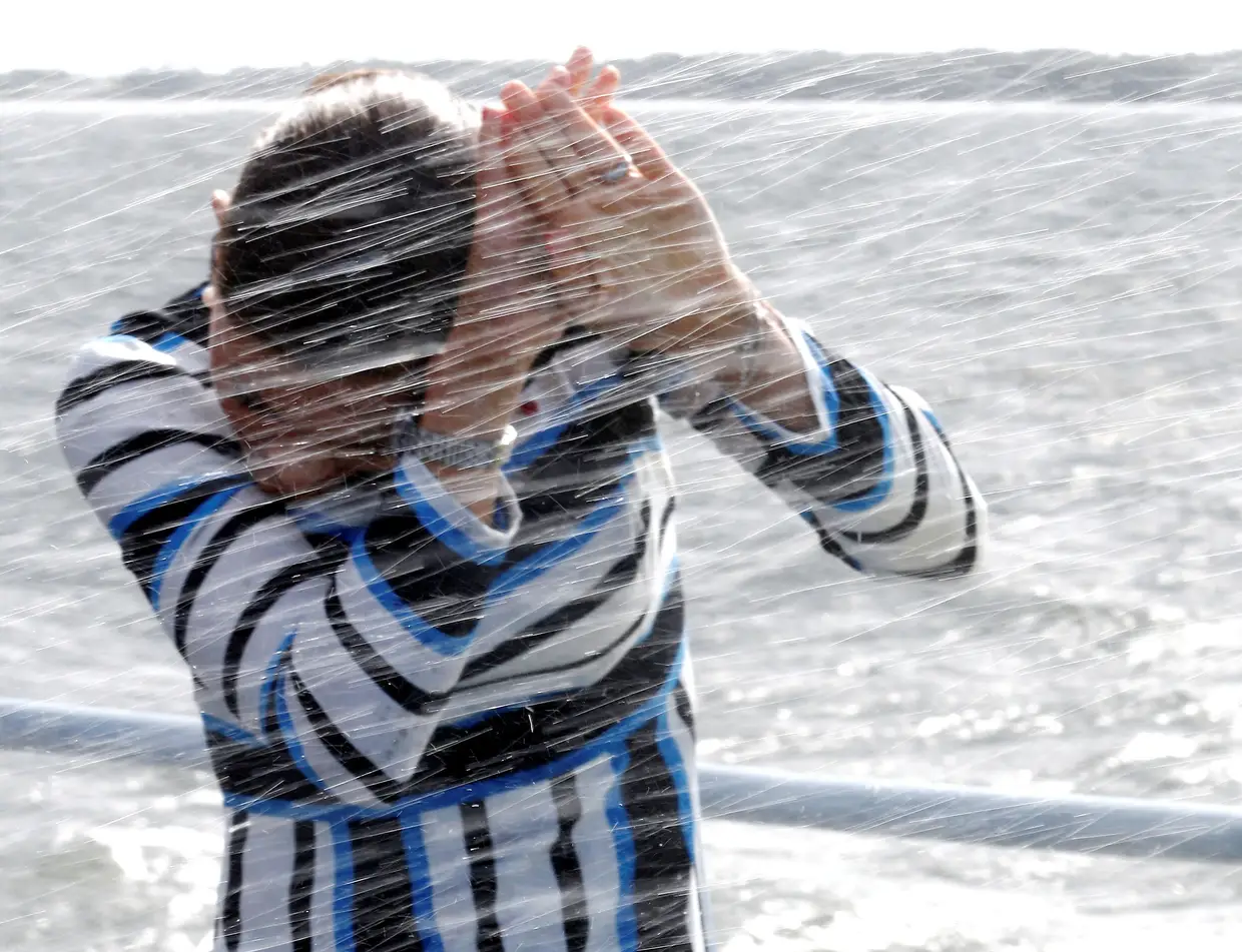 Vitória, Princesa Herdeira da Suécia, protege-se de salpicos de água a bordo do navio da Marinha da Estónia "Wambola", perto de Tallinn.