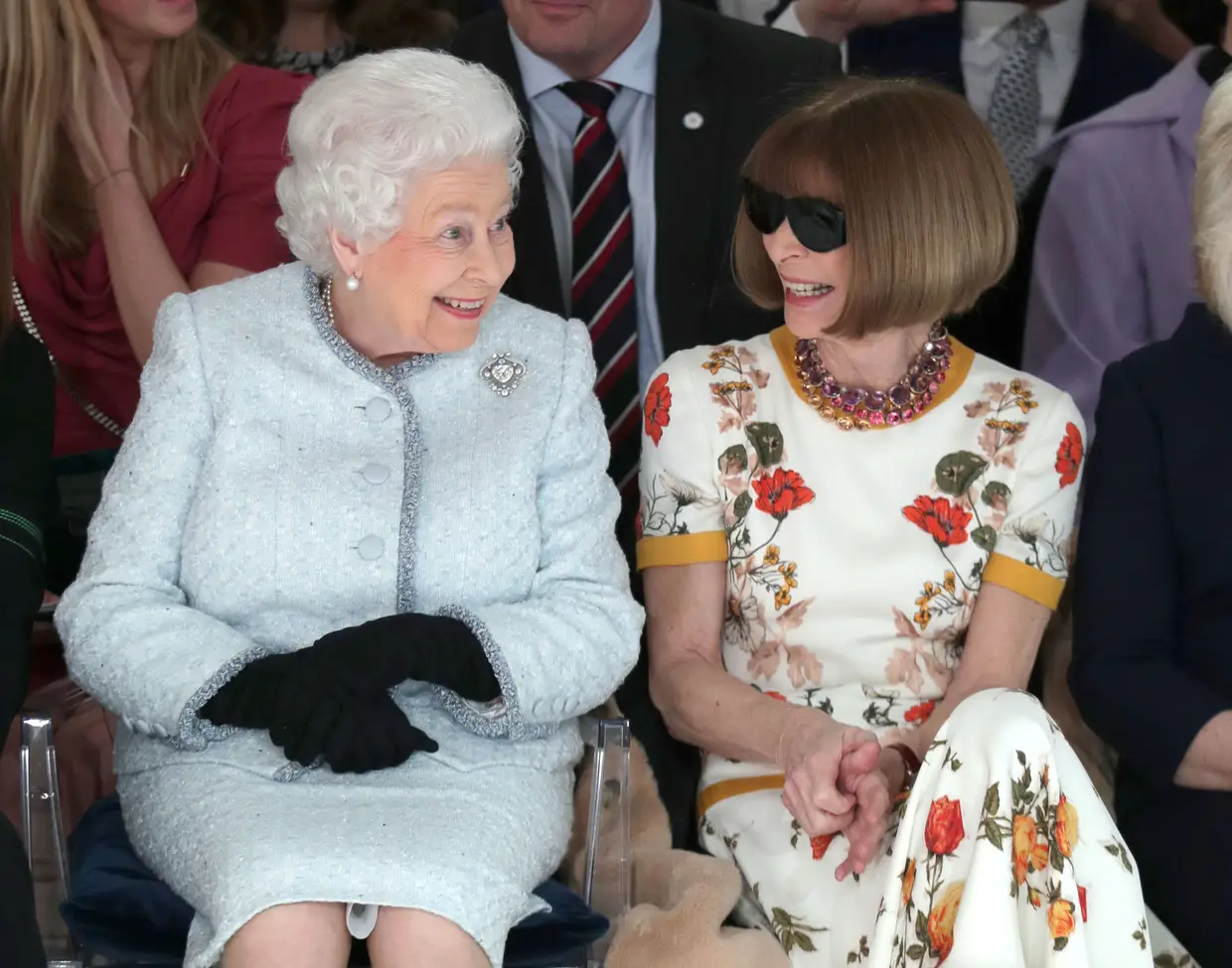 A Rainha Isabel II senta-se ao lado da editora-chefe da revista Vogue, Anna Wintour, para assistir ao desfile de Richard Quinn, galadoardo com o prémio "Queen Elizabeth II Award for British Design".