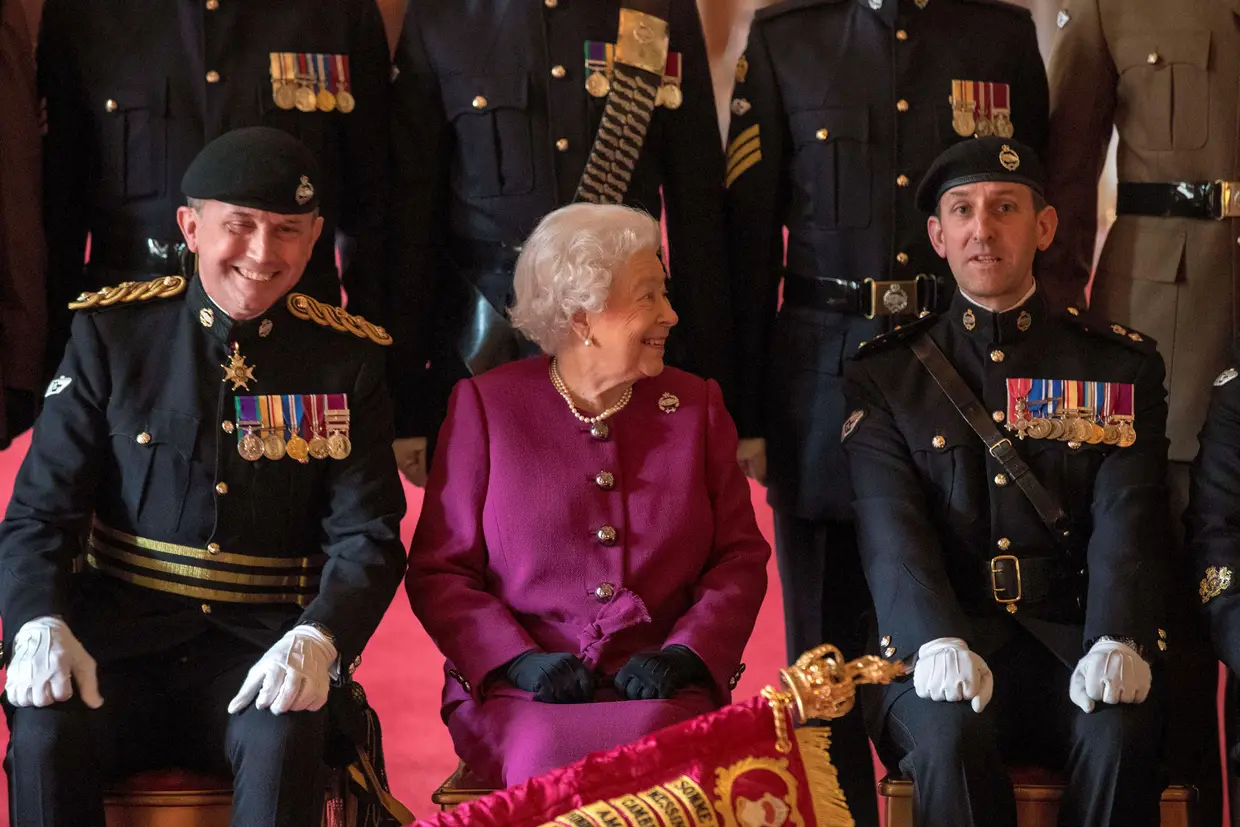 A Rainha Isabel II posa para uma fotografia com o coronel-chefe do Royal Tank Regiment, depois de apresentar o novo estandarte da unidade no Castelo de Windsor.