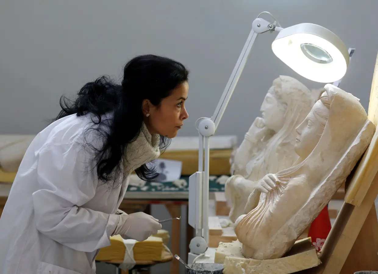 Uma especialista trabalha na estátua danificada de Palmyra, no Museu Nacional de Damasco, na Síria.