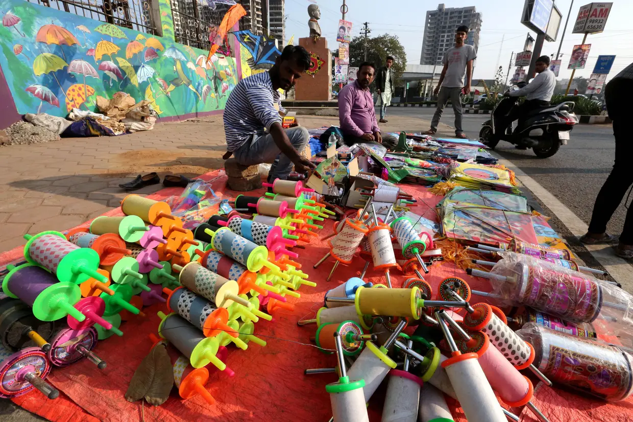 Um vendedor indiano de papagaios de papel junto ao festival Makar-Sankranti (Uttarayan), em Bhopal, na Índia, onde é disputada uma competição de papagaios de papel.