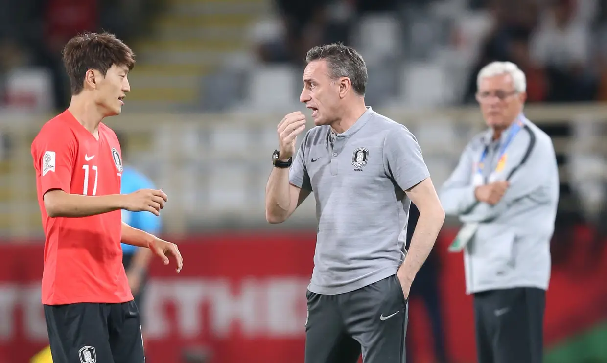 Paulo Bento fala com o seu jogador, Lee Chung-yong, durante um jogo da Coreia do Sul frente à China, para a Taça da Ásia de Futebol. O técnico nacional garantiu o pleno de vitórias no Grupo C da competição, sendo que a Coreia do Sul já estava apurada para os oitavos.