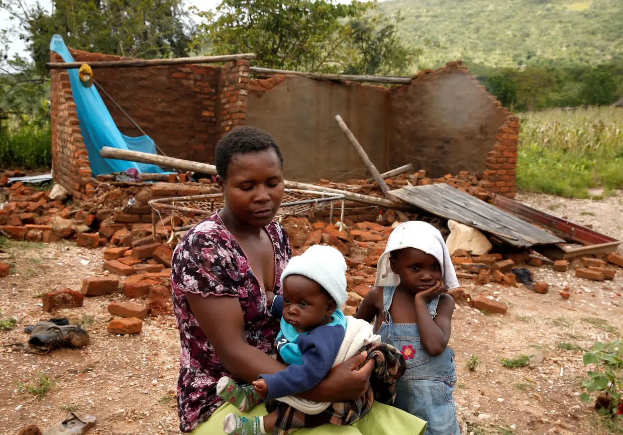 Nomatter Ncube e os filhos ao lado da casa destruída em Chimanimani, Zimbabué