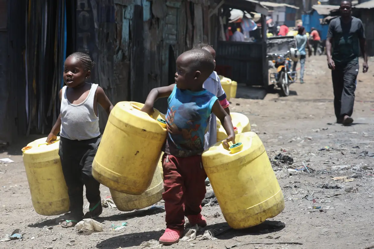 Crianças carregam bidões para encher com água, no Dia Mundial da Água, em Nairobi, Quénia.