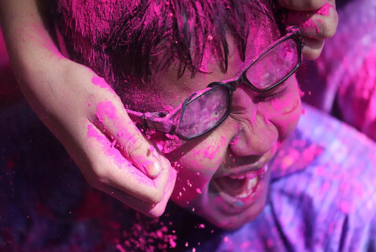 Uma criança coberta de tinta nas celebrações anuais Holi, em Mumbai, na Índia.