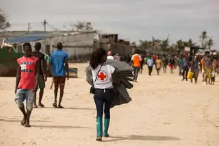 Uma voluntária da Cruz Vermelha transporta mantimentos para os sobreviventes do ciclone Idai