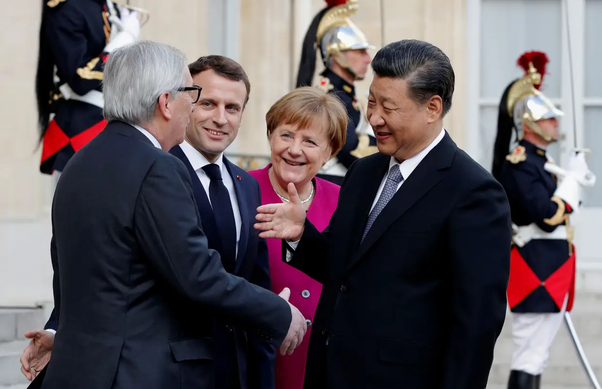 O presidente francês, Emmanuel Macron, a chanceler alemã, Angela Merkel, e o presidente da Comissão Europeia, Jean-Claude Juncker, dão as boas-vindas ao presidente chinês, Xi Jinping, no Palácio do Eliseu, em Paris.