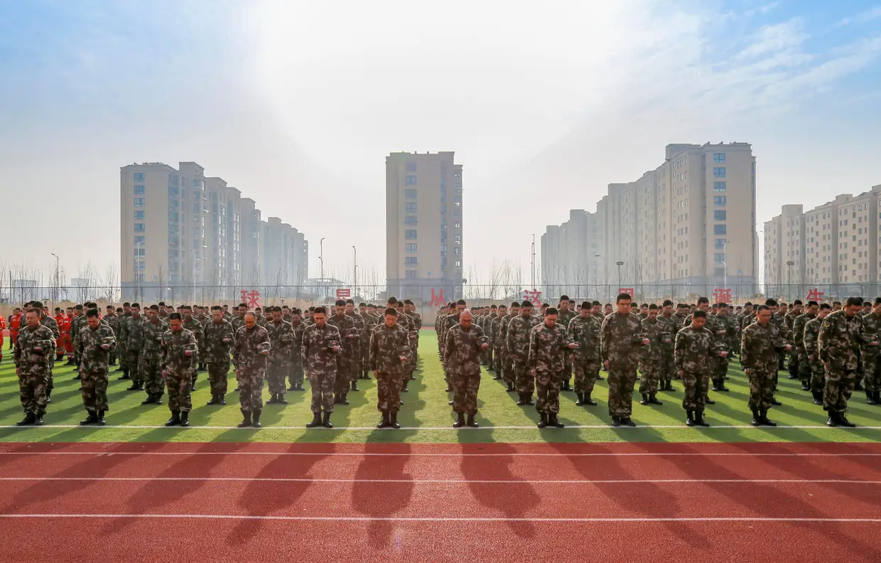 Militares numa homenagem às 78 vítimas mortais da explosão num parque industrial em Yancheng, província de Jiangsu, China.