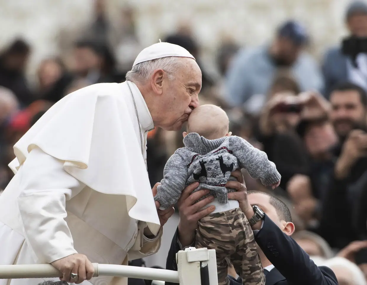 O Papa Francisco beija uma criança, na Praça de São Pedro, no Vaticano.