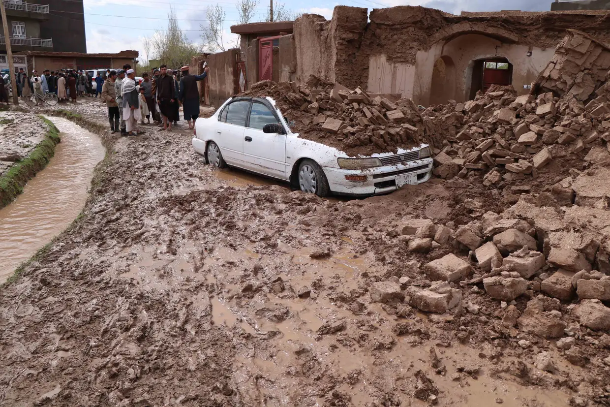 O povo afegão inspeciona casas danificadas após as cheias em Herat.