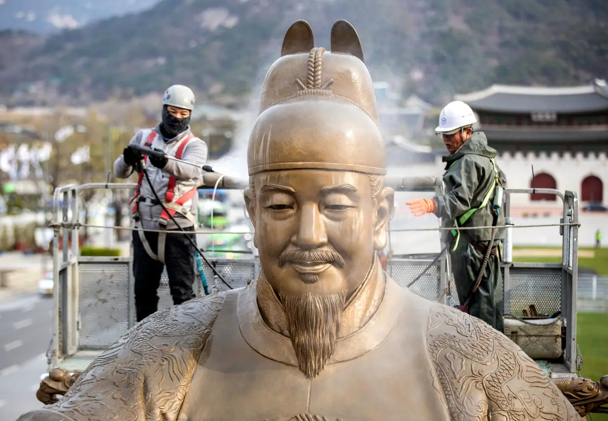 Trabalhadores limpam a estátua do rei Sejong, na Praça de Gwanghwamun, Seul, Coreia do Sul.