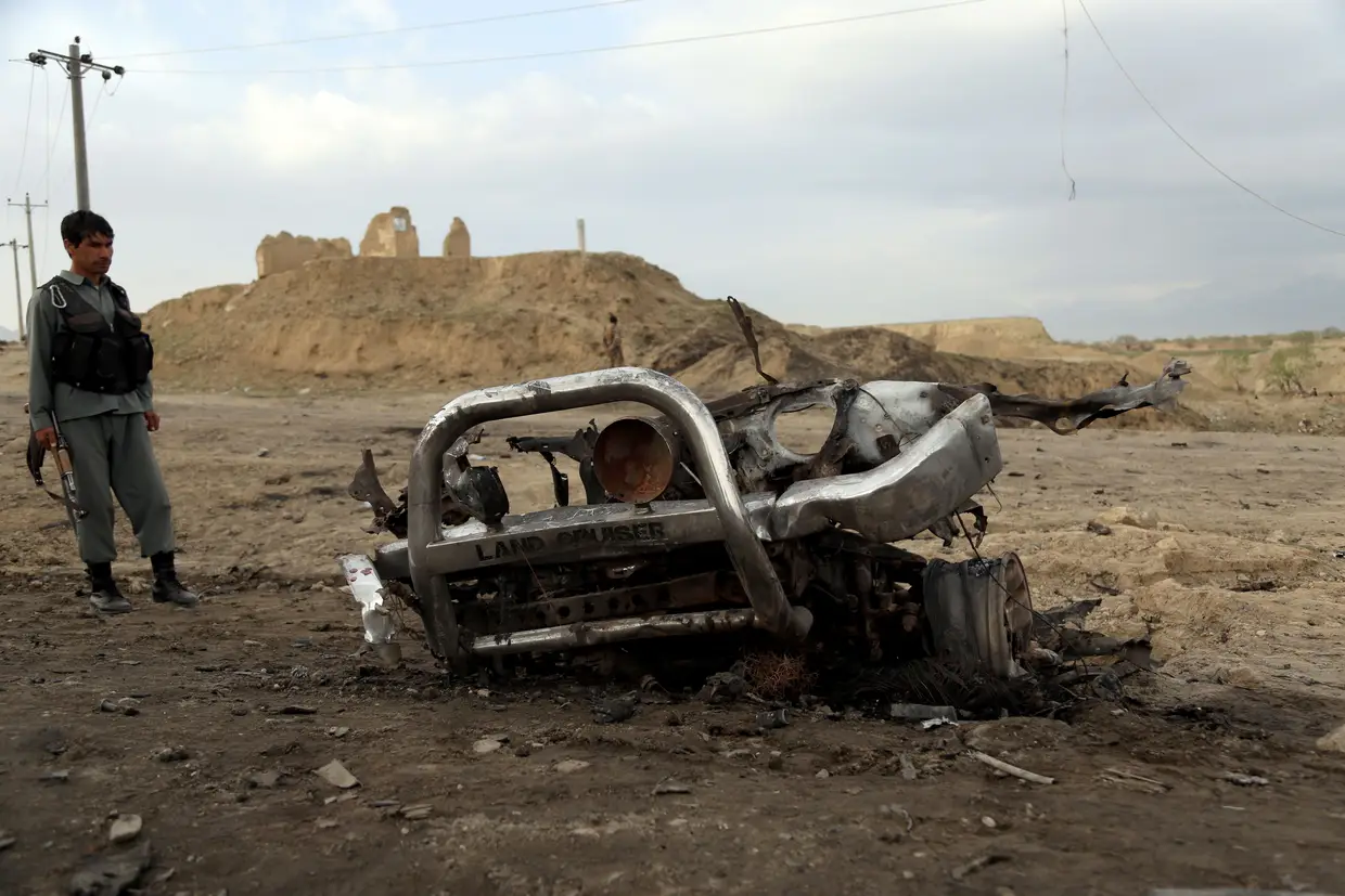 Um soldado afegão olha para a destruição causada por um carro-bomba, perto da base aérea de Bagram, nos subúrbios de Cabul, Afeganistão. Pelo menos três militares norte-americanos morreram e outros quatro ficaram feridos.