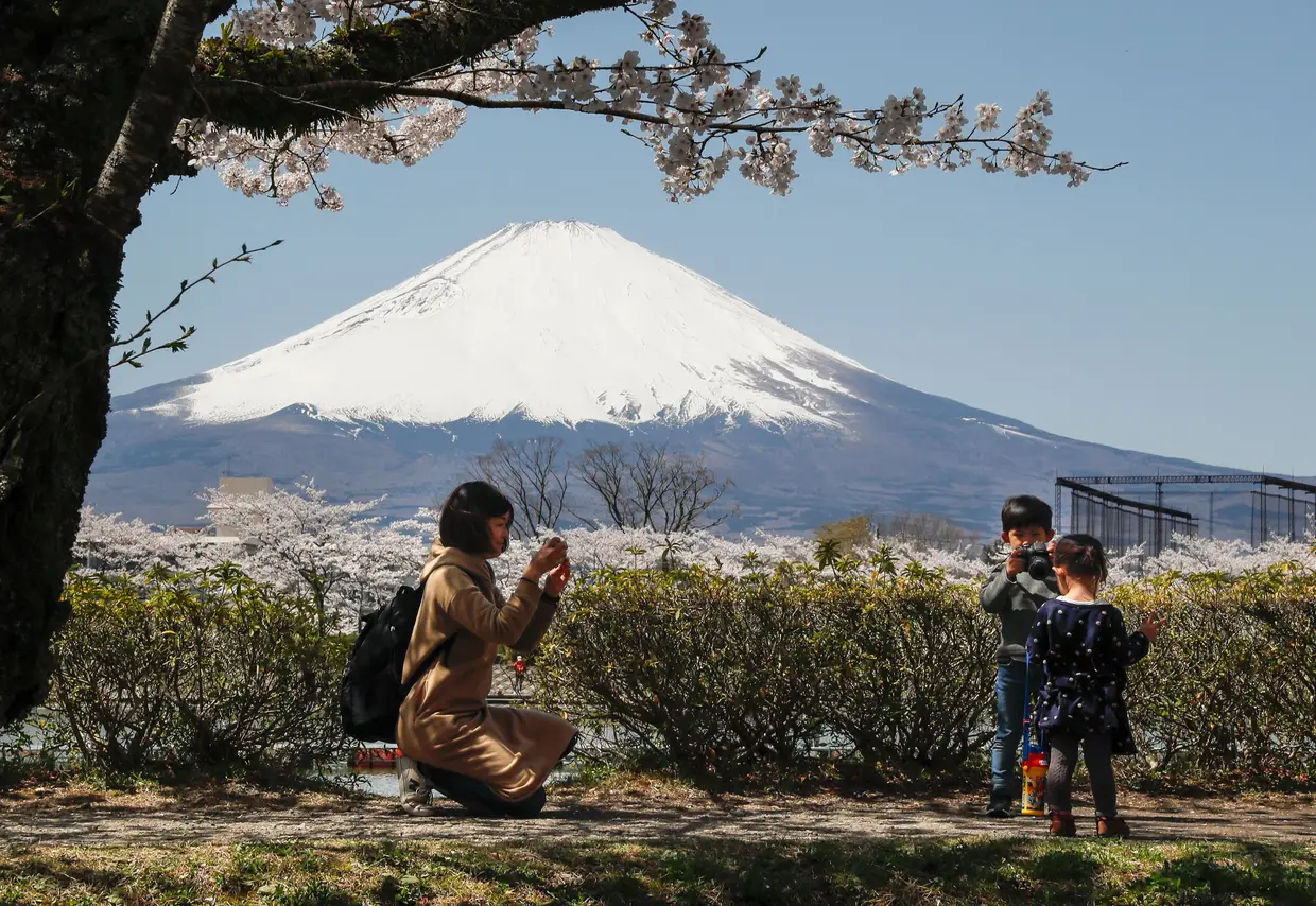 Uma mulher tira fotografias a crianças, no miradouro do Monte Fuji, em Gotemba, no Japão.