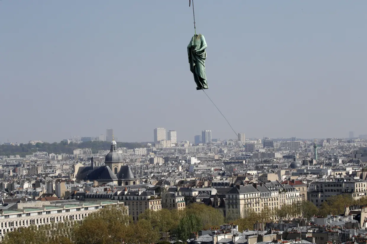 A estátua de Saint John é removida da Catedral de Notre Dame, em Paris, França.