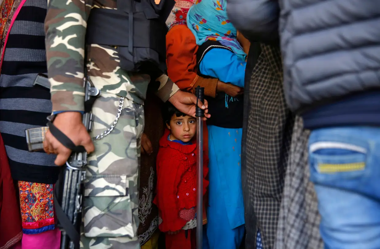 Uma criança entre os eleitores que esperam na fila para votar, Srinagar, a capital de verão da Caxemira indiana.