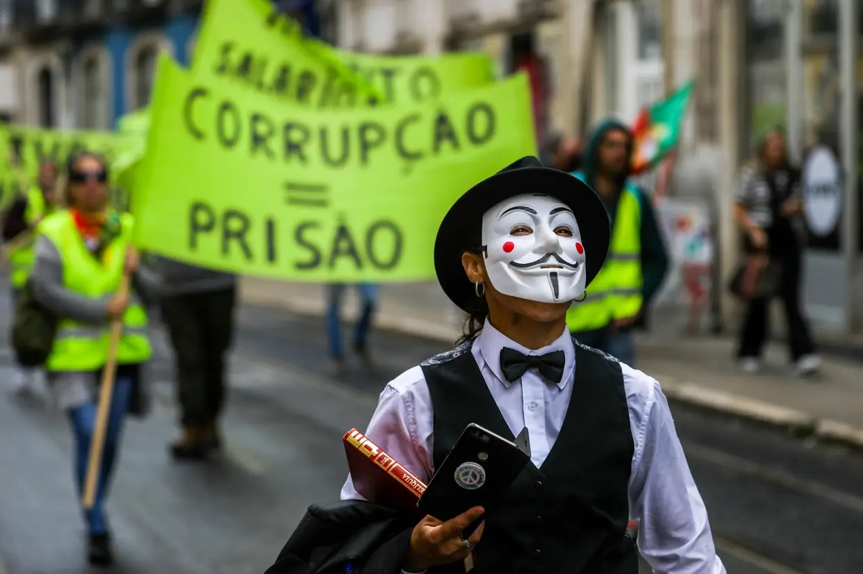 Uma mulher com a máscara de Guy Fawkes participa numa ação de protesto do Movimento Coletes Amarelos Portugal (MCAP), em conjunto com os restantes grupos Coletes Amarelos Portugueses, entre a Praça do Comércio e a Assembleia da República, em Lisboa.