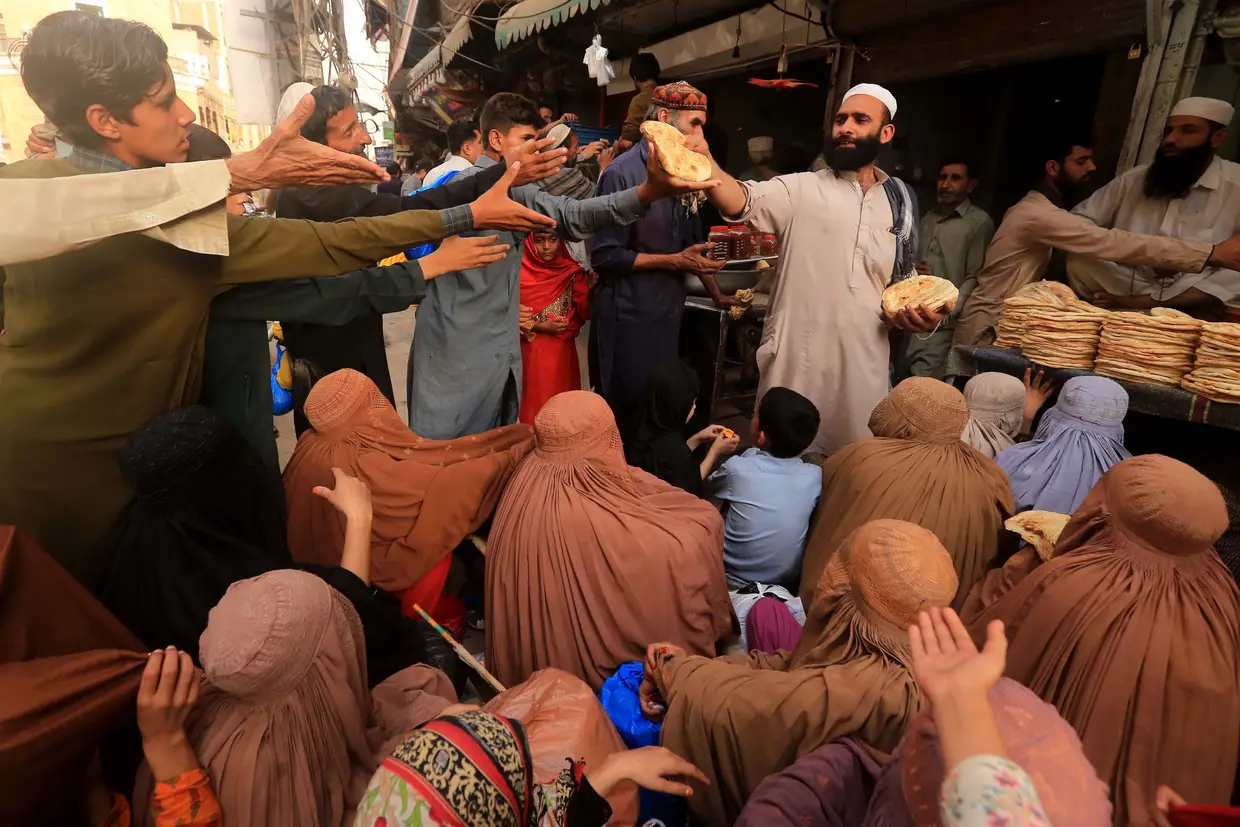 Pessoas recebem pão grátis durante o Ramadão, em Peshawar, no Paquistão.