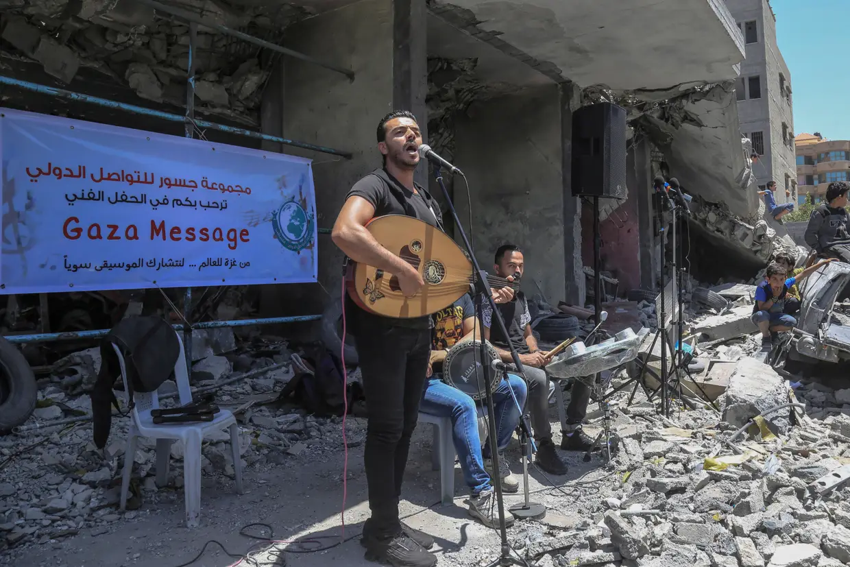 Um músico palestiniano canta, no meio dos destroços causados pelos ataques aéreos israelitas a Gaza, num evento que pede o boicote à Eurovisão, que tem lugar em Israel.