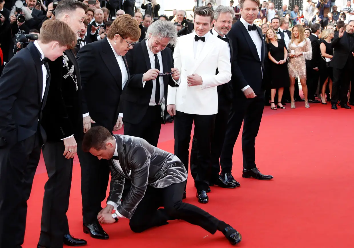 Taron Egerton arranja as calças de Elton John à chegada do Festival de Cinema de Cannes, França.