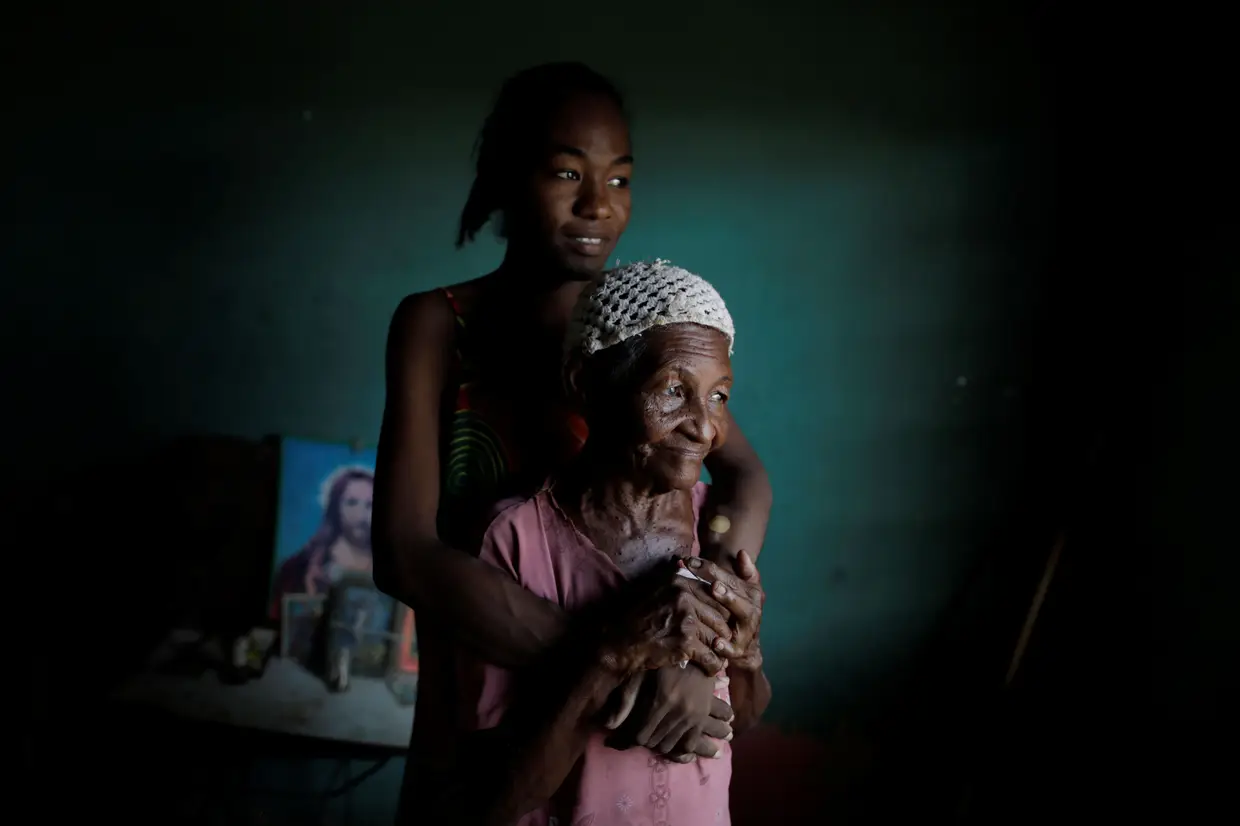 Uma jovem posa para uma fotografia com a avó, durante um apagão em La Concepción, na Venezuela.