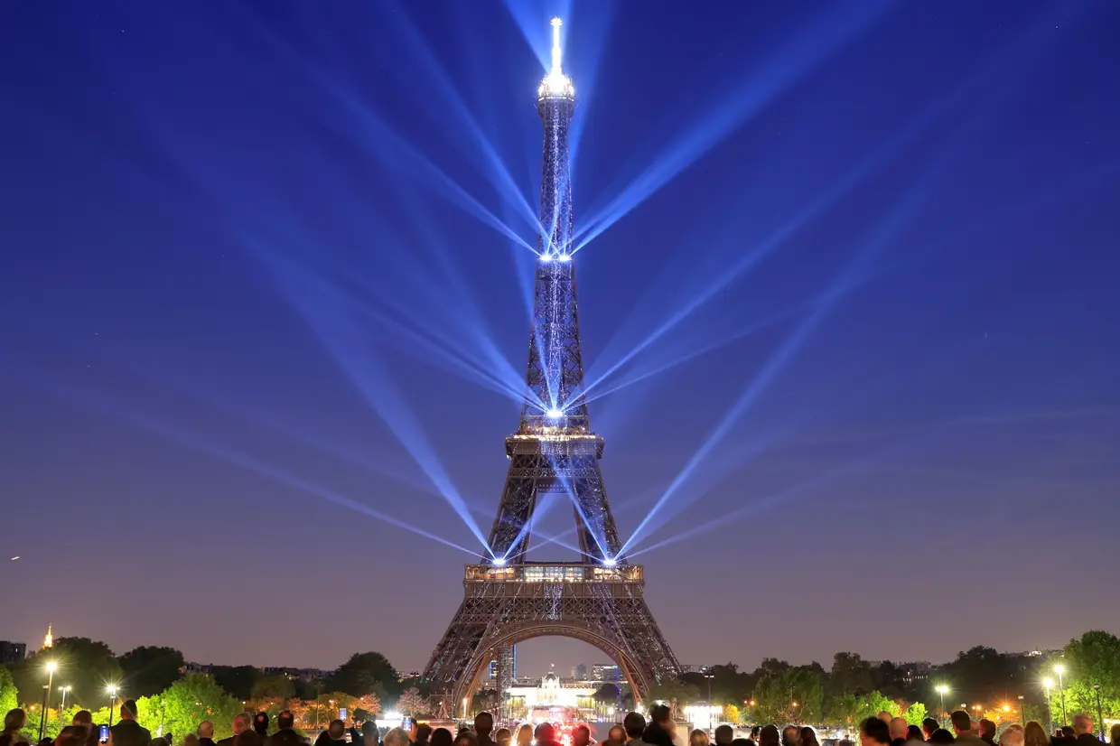 A Torre Eiffel iluminada durante o seu 130.º aniversário, Paris, França.