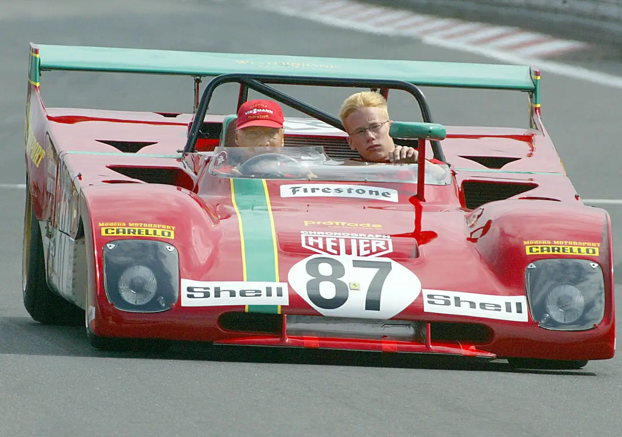 De volta aos carros, Niki Lauda não conseguia manter-se afastado das pistas. Esta foto de 2003 mostra mais um regresso ao circuito de Nuerburgring, desta vez para o festival anual da Ferrari, onde fãs e amantes de carros de luxo apresentam veículos velhos e jovens