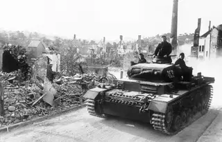 Taque nazi avança pela destruída aldeia francesa de Aisne, 1940.