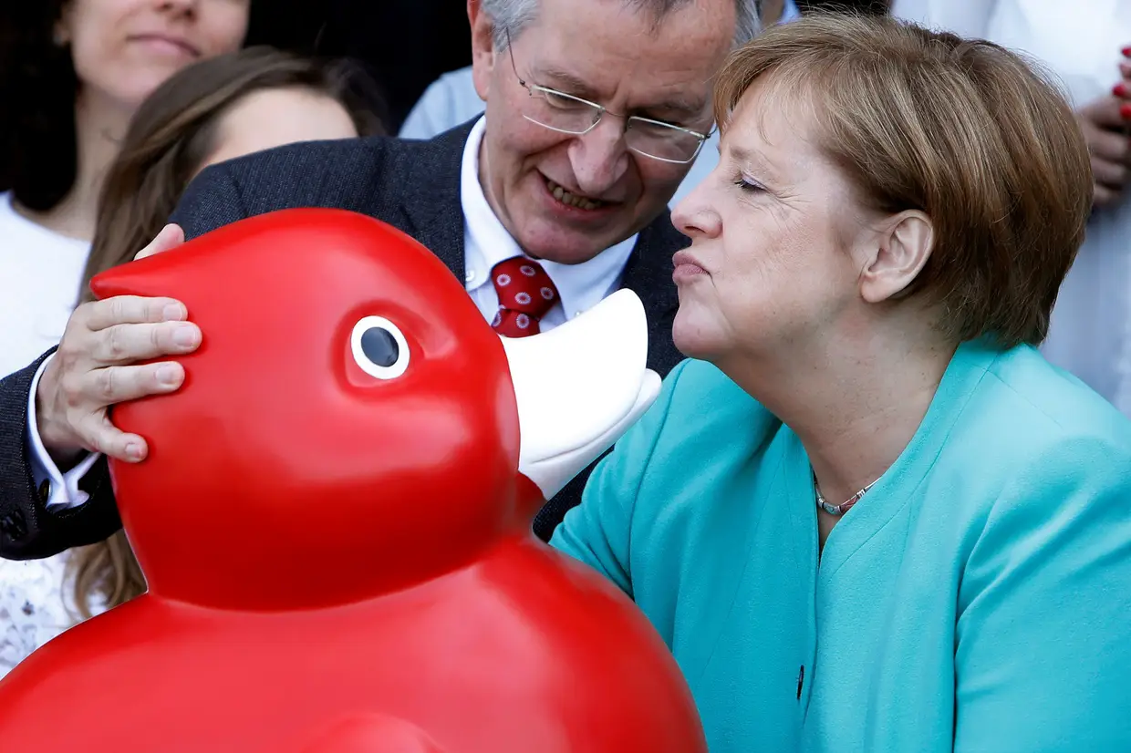 A chanceler alemã Angela Merkel recebe um pato de brincar durante uma visita à empresa de biotencologia Centogene em Rostock, na Alemanha