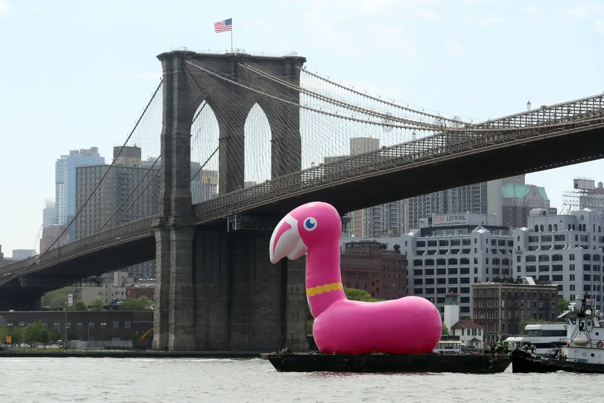 Um flamingo insuflável é transportado ao longo do rio East, em Nova Iorque, EUA.