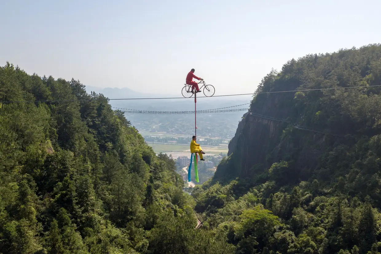 Acrobacias numa corda bamba no parque de Shiniuzhai, na China.