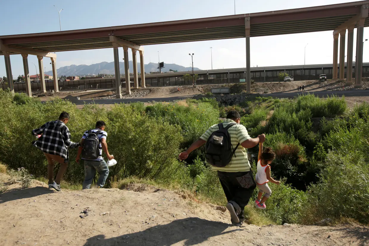 Migrantes atravessam a fronteira entre o México e os Estados Unidos.