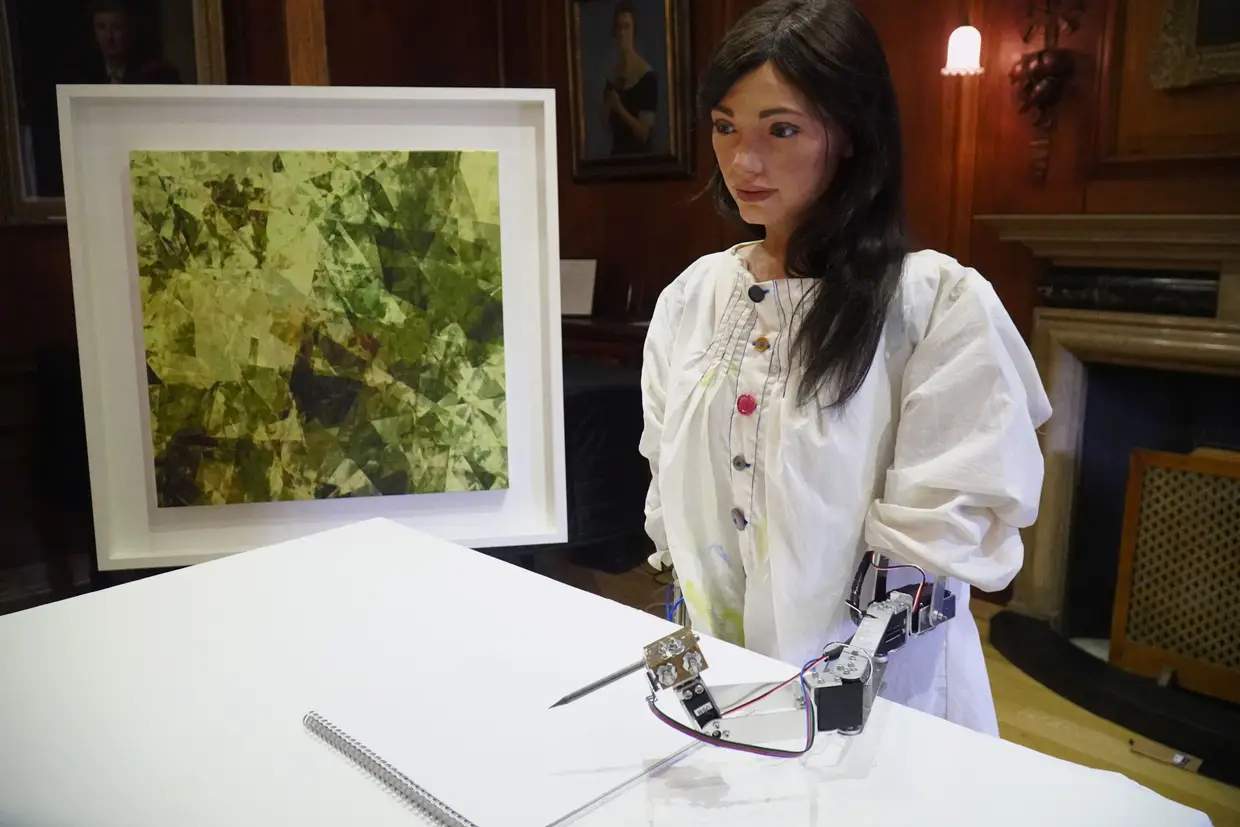 A artista robô Ai-Da usa um lápis para copiar o quadro que tem ao lado, Oxford, Inglaterra.