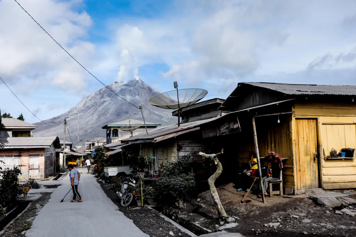 Um homem limpa as cinzas em Karo, Sumatra do Norte, Indonésia, deixadas pelo Monte Sinabung, que entrou em erupção.