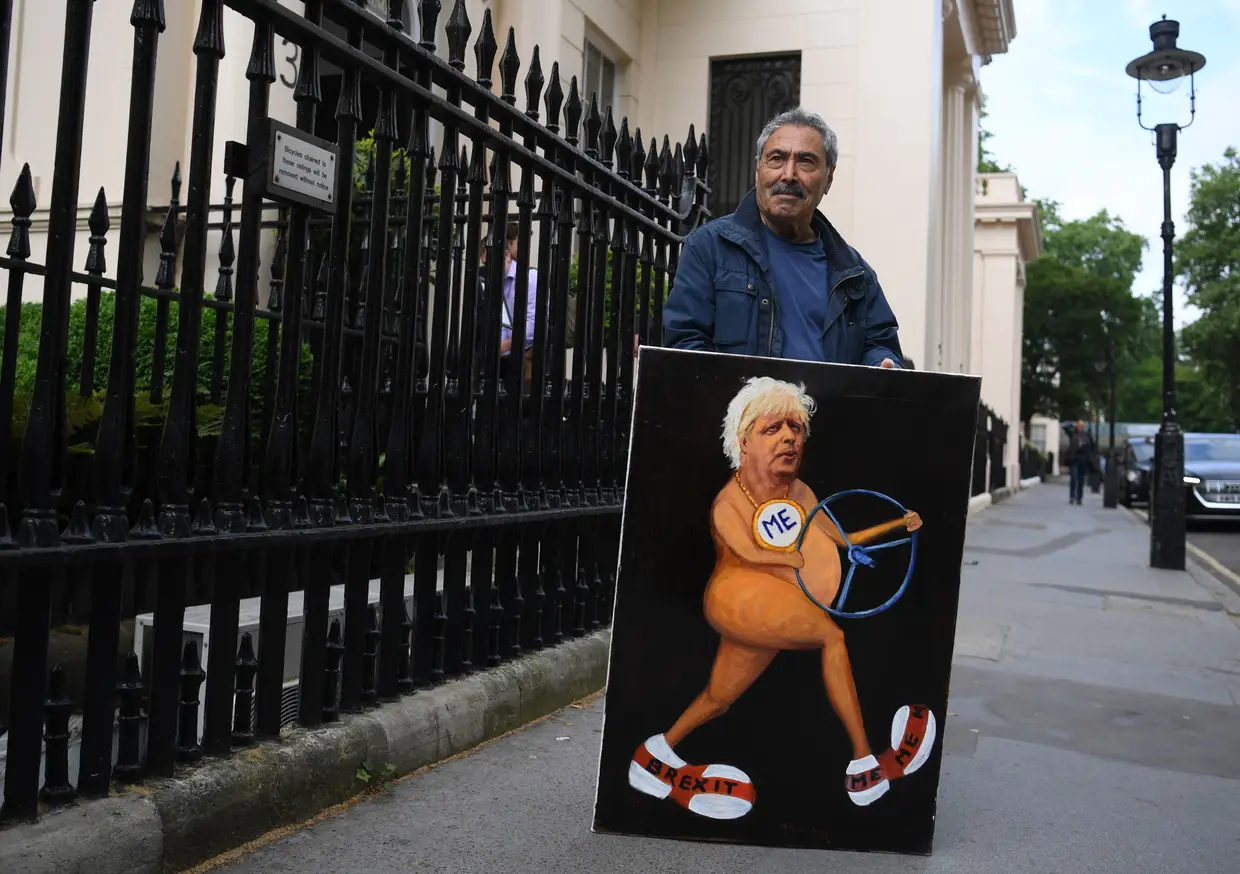 Um artista mostra o seu cartoon de Boris Johnson, em Londres, Inglaterra.