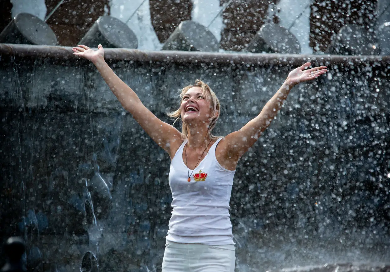 Mulher refresca-se numa fonte do Alexander Garden em Moscovo, na Rússia