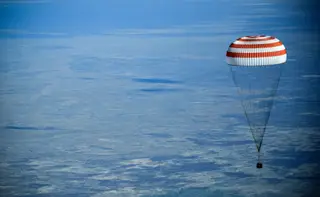 O para-quedas que trouxe Anne McClain, Oleg Kononenko e David Saint-Jacques até à superfície terrestre após uma missão de seis meses na Estação Espacial Internacional.