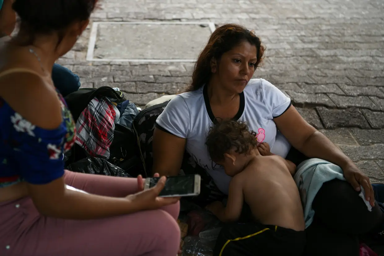 Refugiada hondurenha senta-se com o filho de um ano de idade num acampamento de mirgantes improvisado em Tamaulipas, México