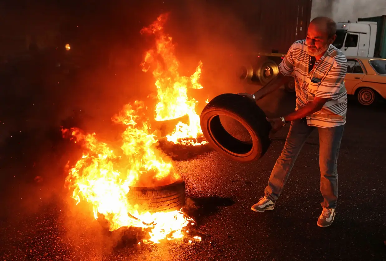 Veterano do exército libanês queima pneus durante um protesto contra o orçamento do Estado no sul de Beirute, no Líbano