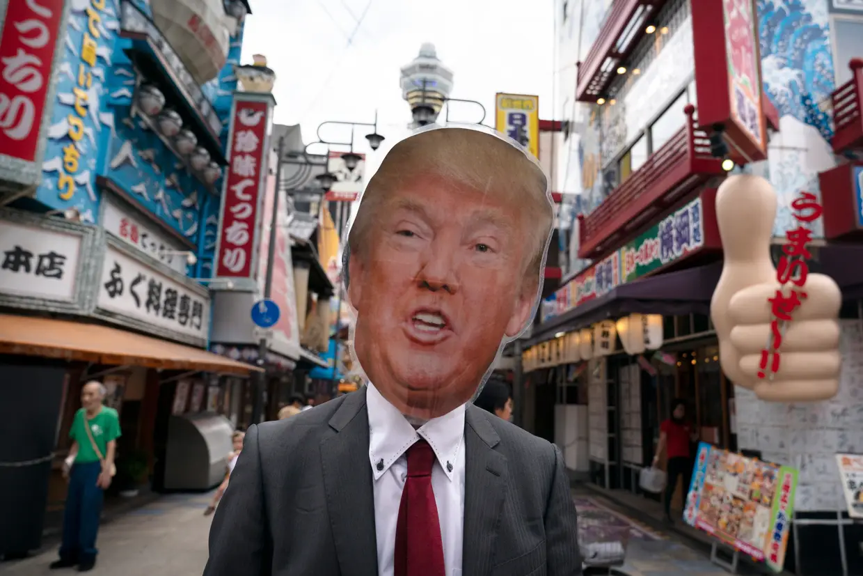 Ativista ambiental usa máscara com a cara de Donald Trump durante um protesto contra o uso do carvão, em Osaka, no Japão, onde se realiza a cimeira do G20