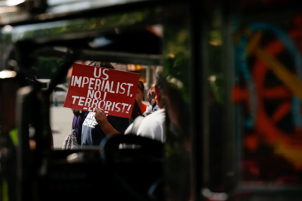 Um jovem ativista segura num cartaz durante um protesto, em frente à embaixada norte-americana, em Manila, contra as relações entre o Governo das Filipinas e o dos Estados Unidos da América.