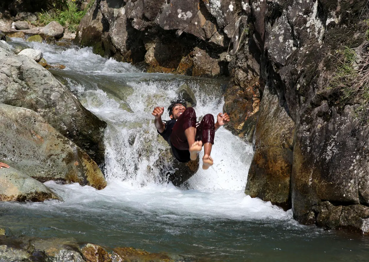 Um homem refresca-se num rio em Srinagar, a capital de verão da Caxemira indiana.