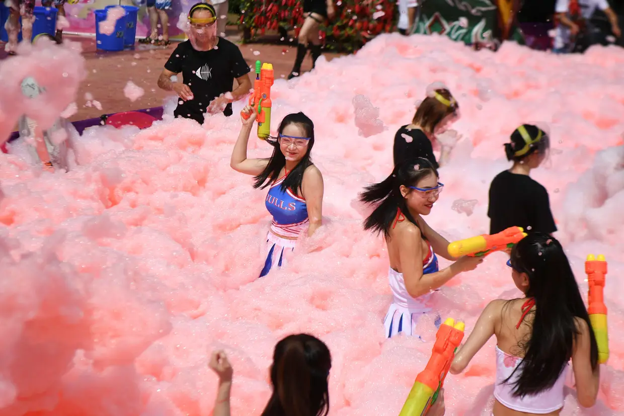 Num dia de calor em Ningxiang, China, uma piscina cheia de água fria e espuma.
