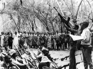 Fuzileiros e novos recrutas das Forças de Libertação Nacional recebem treino enquanto os aldeões assistem em Moçambique (4 de dezembro de 1968)