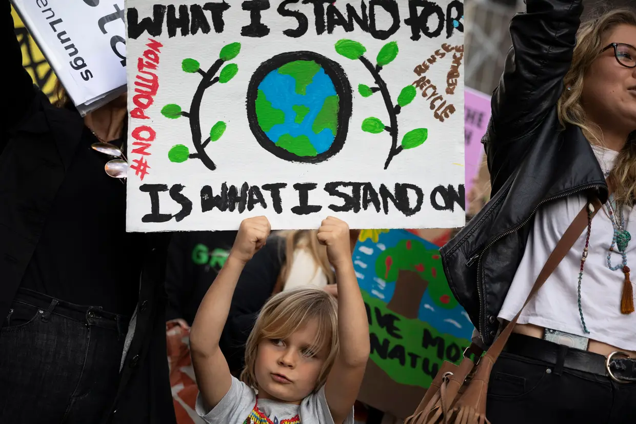 Uma criança participa num protesto do grupo de ativistas Extinction Rebellion, no consulado brasileiro na Cidade do Cabo, África do Sul, para alertar para os incêndios que estão a destruir a floresta da Amazónia e pedir a demissão do Presidente Jair Bolsonaro.