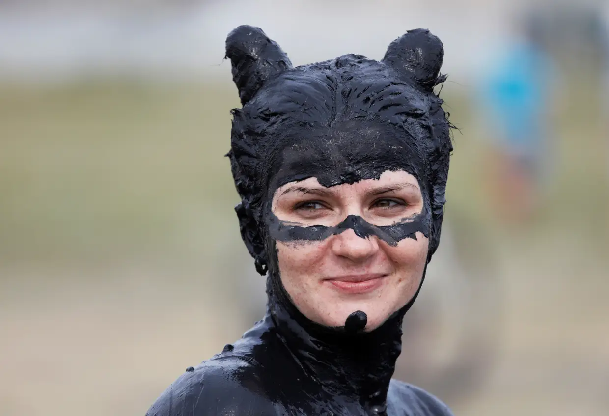Mulher coberta de lama rica em minerais participa no festival "Lama de ferro" na cidade de Zheleznovodsk, na região de Stavropol, na Rússia