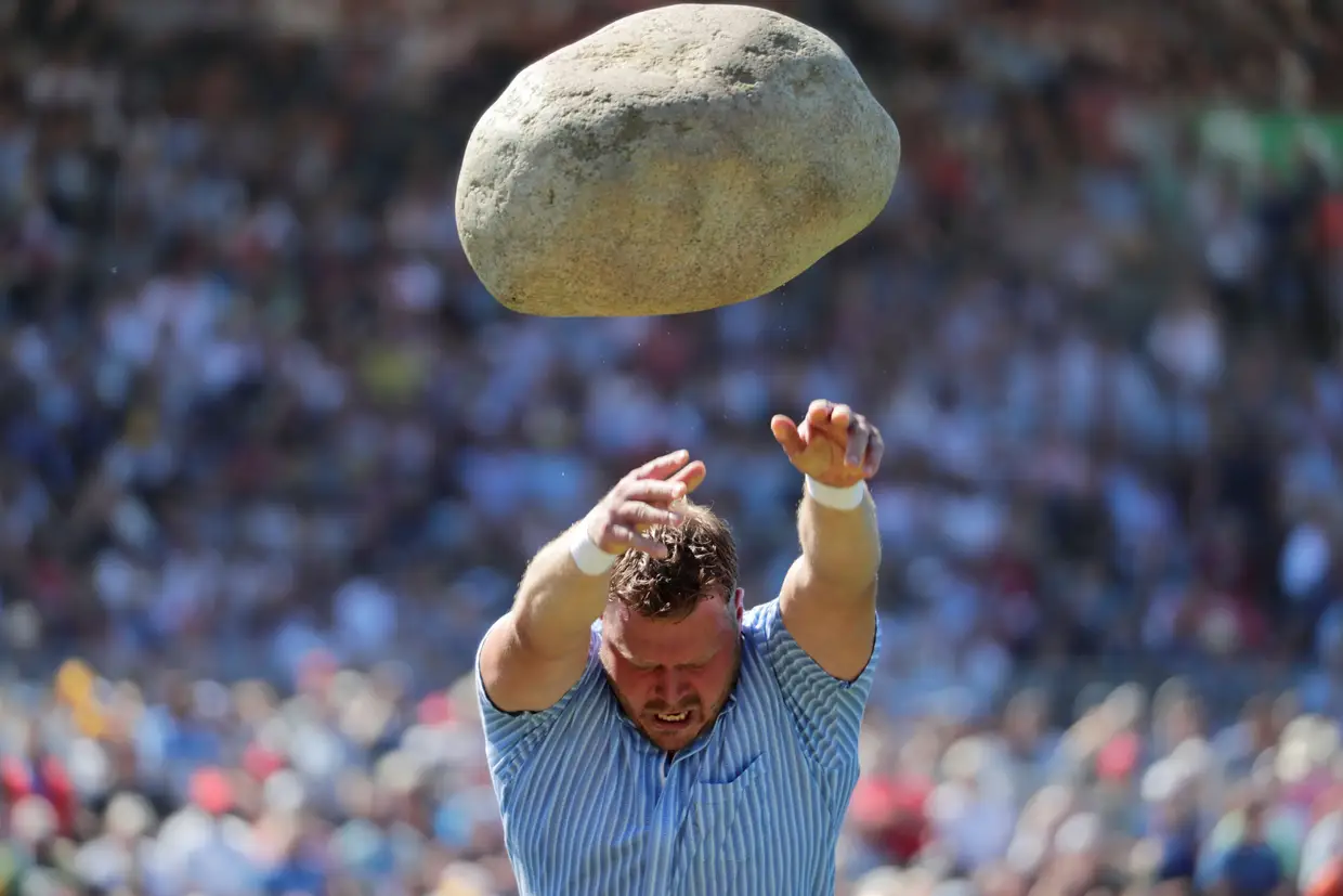 Martin Jakober atira uma pedra com 83,5 kg no Festival de Luta Alpina em Zug, na Suíça.