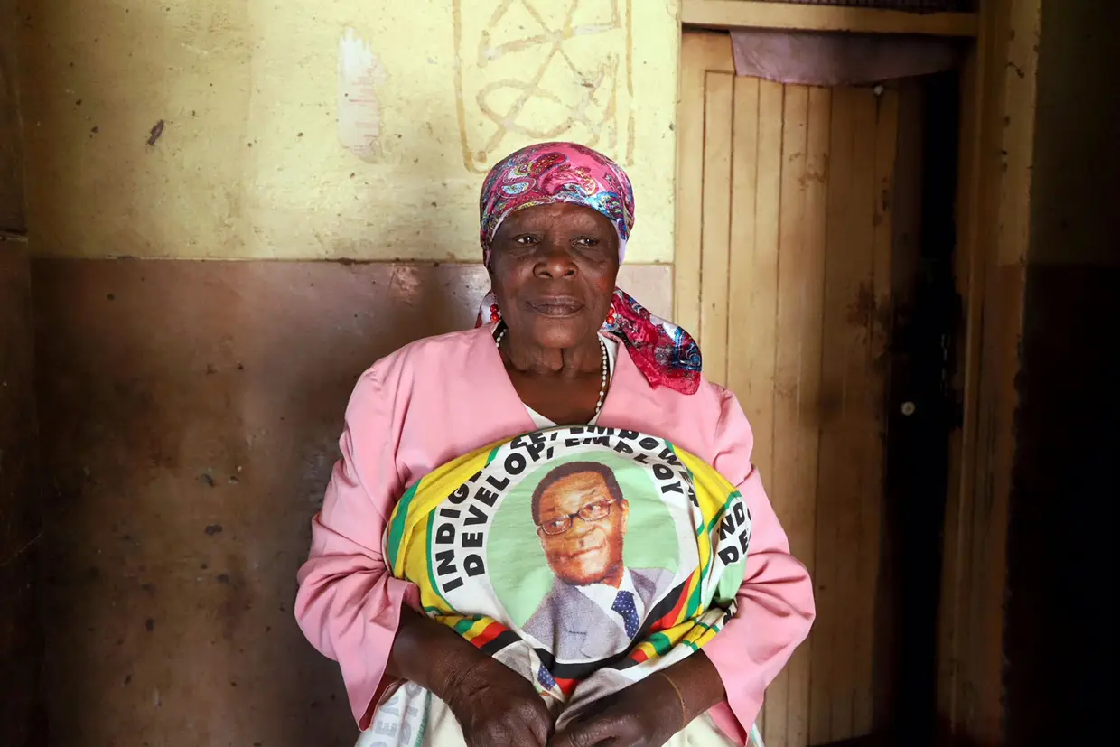 Mulher segura tecido com o retrato do ex-presidente do Zimbábue Robert Mugabe, em Harare