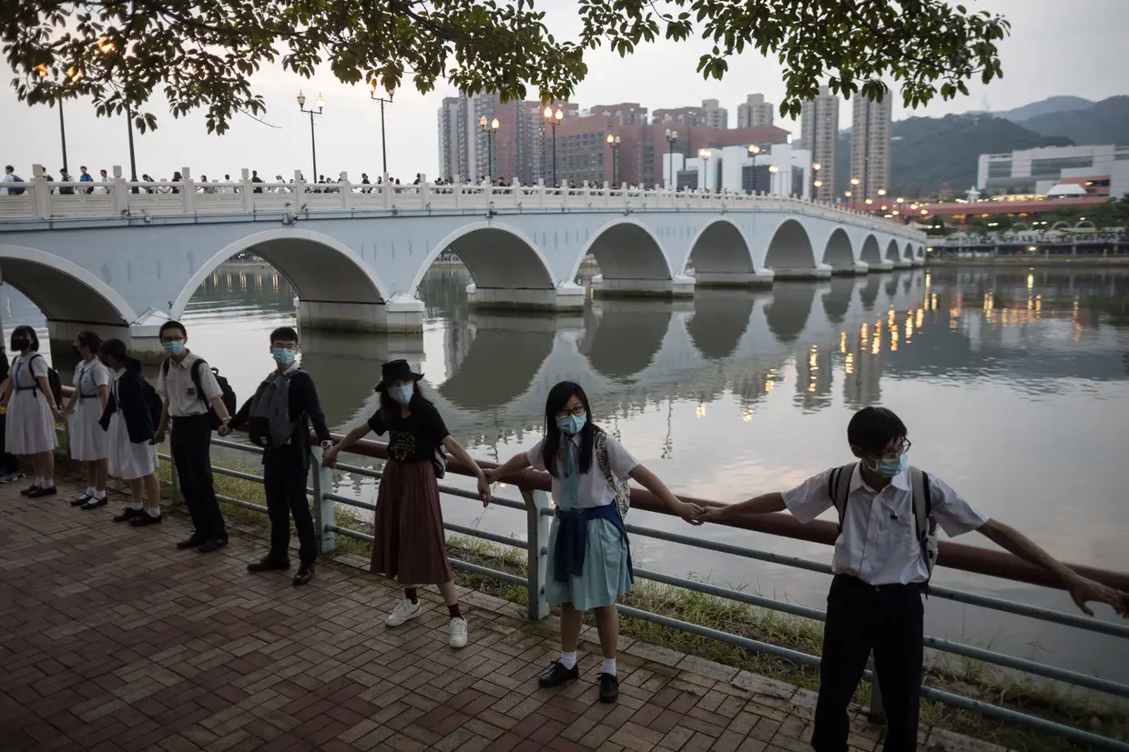 Estudantes do secundário participam num cordão humano contra o governo chinês, em Hong Kong.